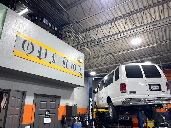 Vehicle on a lift inside the Quiroz Auto Center service bay